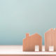 Close up difference of two wood house models on blue background,